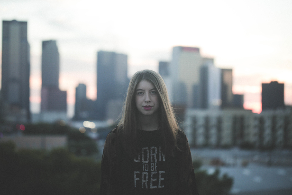 Teen girl in a city wearing a Born to be free sweater
